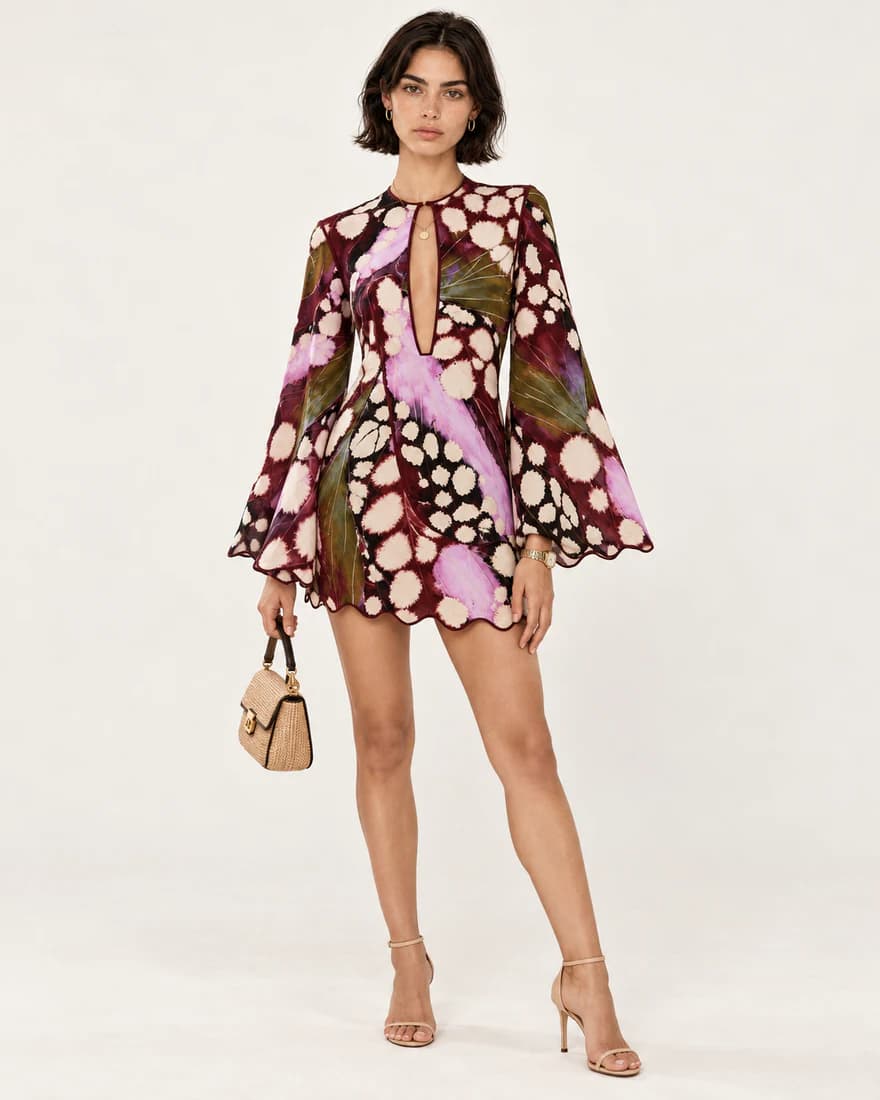 Model in a burgundy butterfly wing print mini dress with flared sleeves