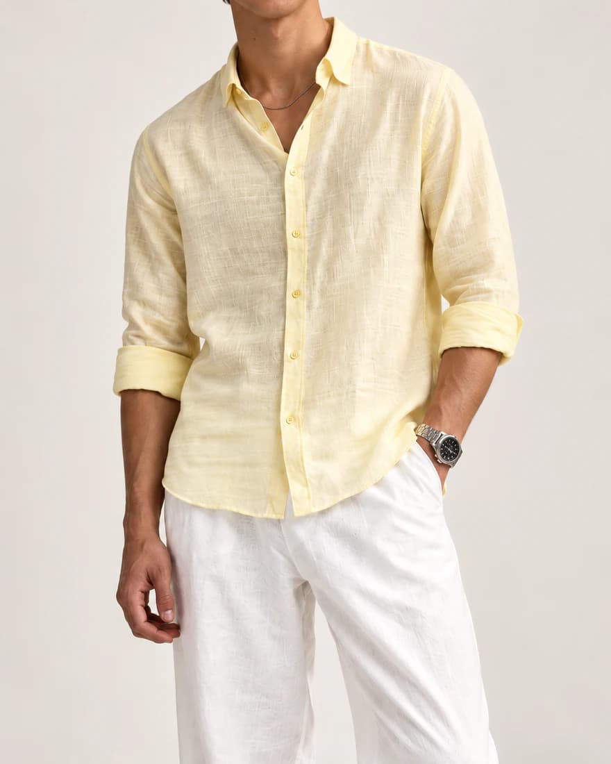 Close-up of a yellow linen shirt worn with white linen trousers
