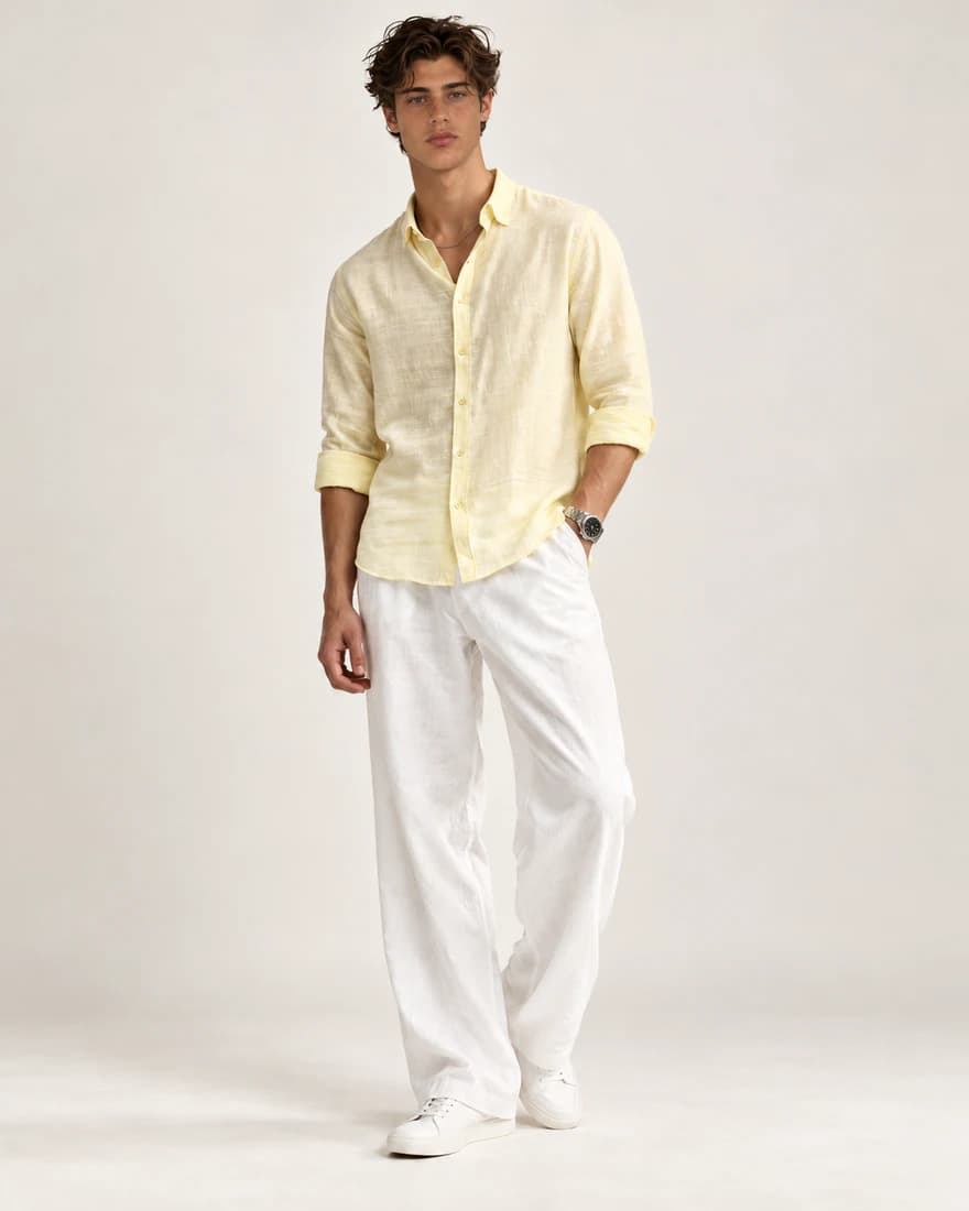 Model in a yellow linen shirt and white linen trousers