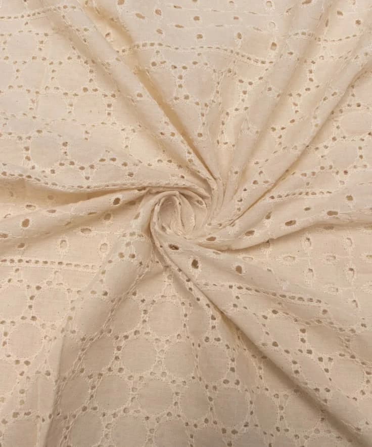 Ivory schiffli eyelet cotton fabric gathered into a swirl