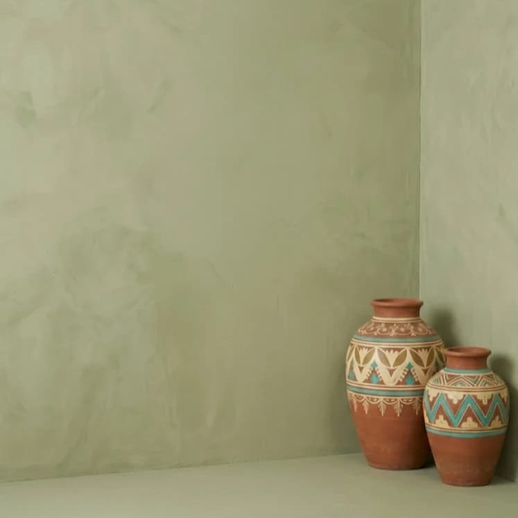 Green studio background with terracotta urns.