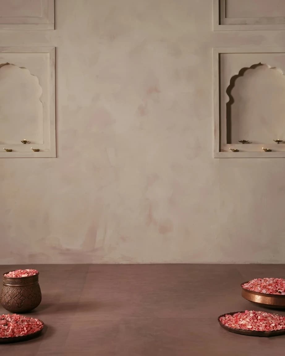 The floor is muted, earthy-toned stone in a dusty rose hue