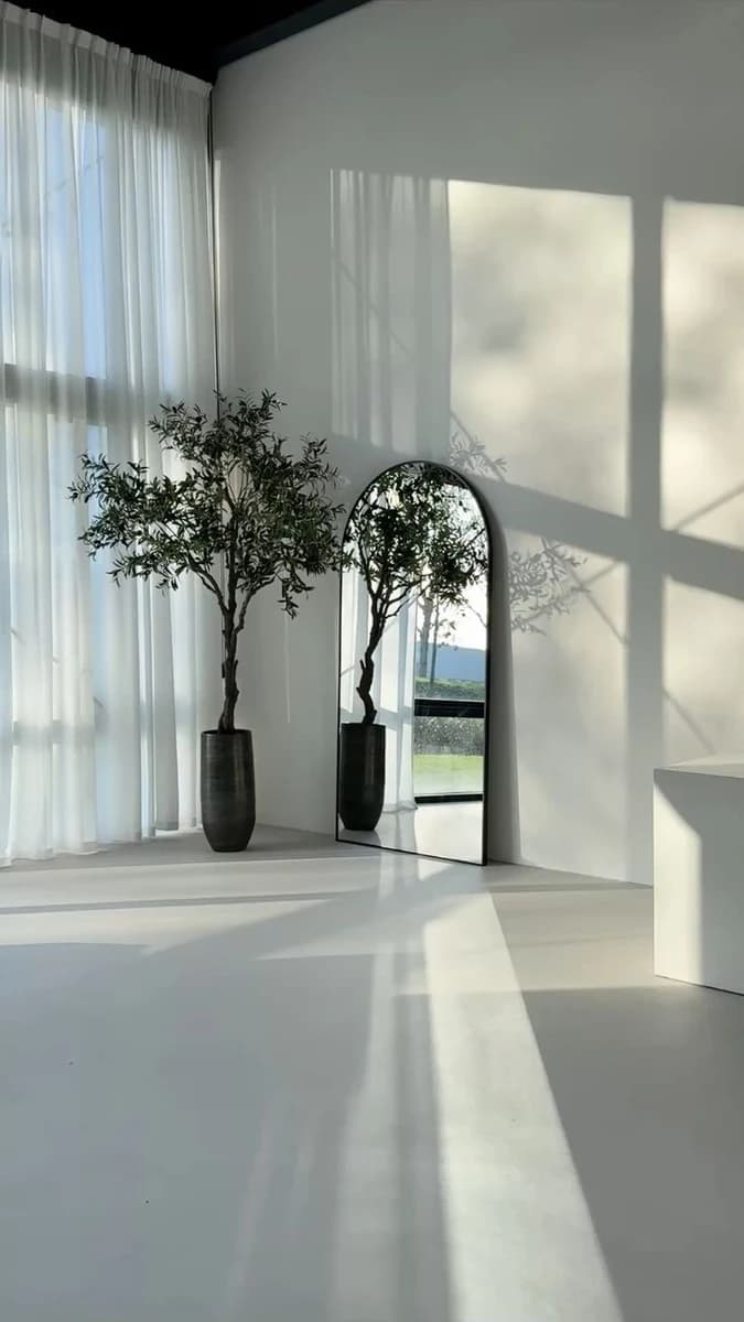 The sun-drenched minimalist arched mirror studio