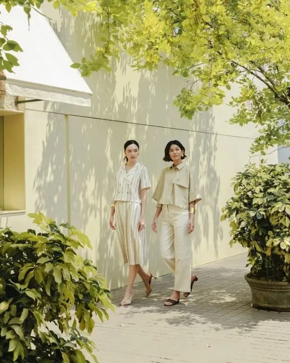 An outdoor architectural and fashion backdrop featuring a quiet, sun-drenched pathway.